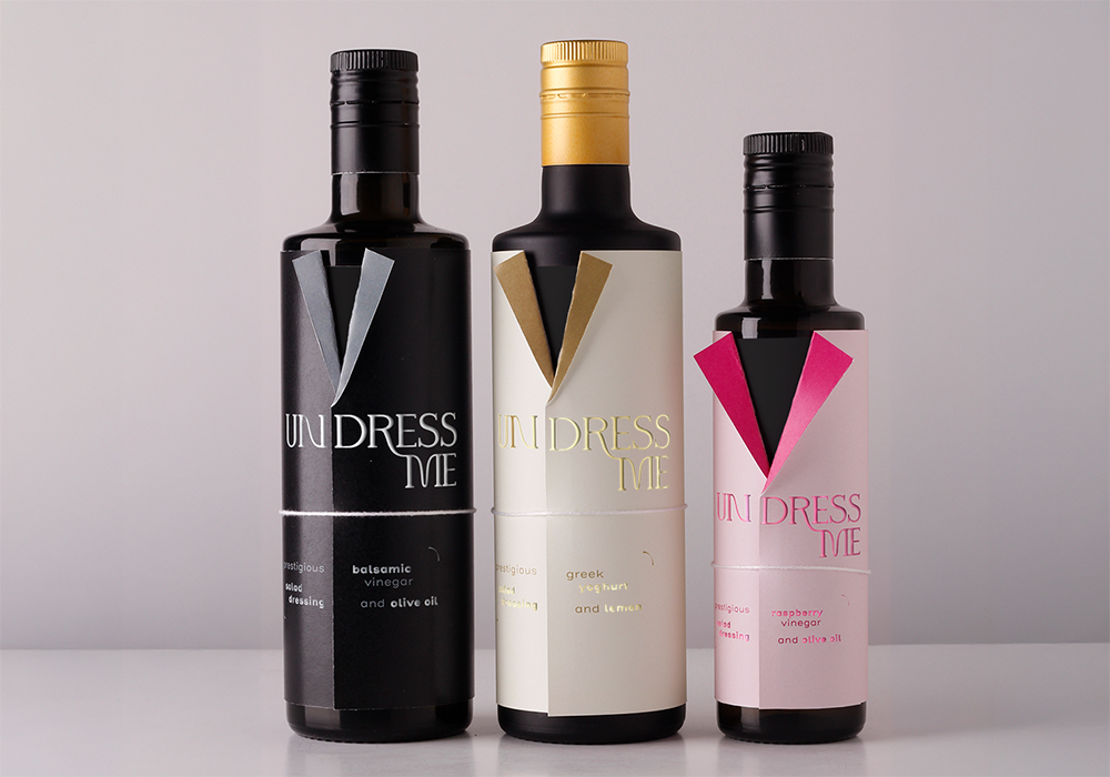 Three bottles of vinegar with a label in the shape of a jacket, with as title undress me