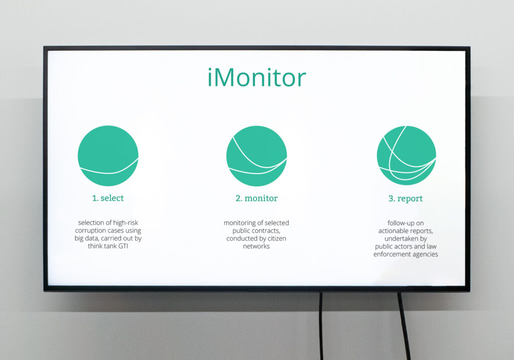 large tv with the logo of imonitor, displayed with 3 green rounds, one with a line inside, the second with two lines and the third with three lines. It explains the construction of the logo 