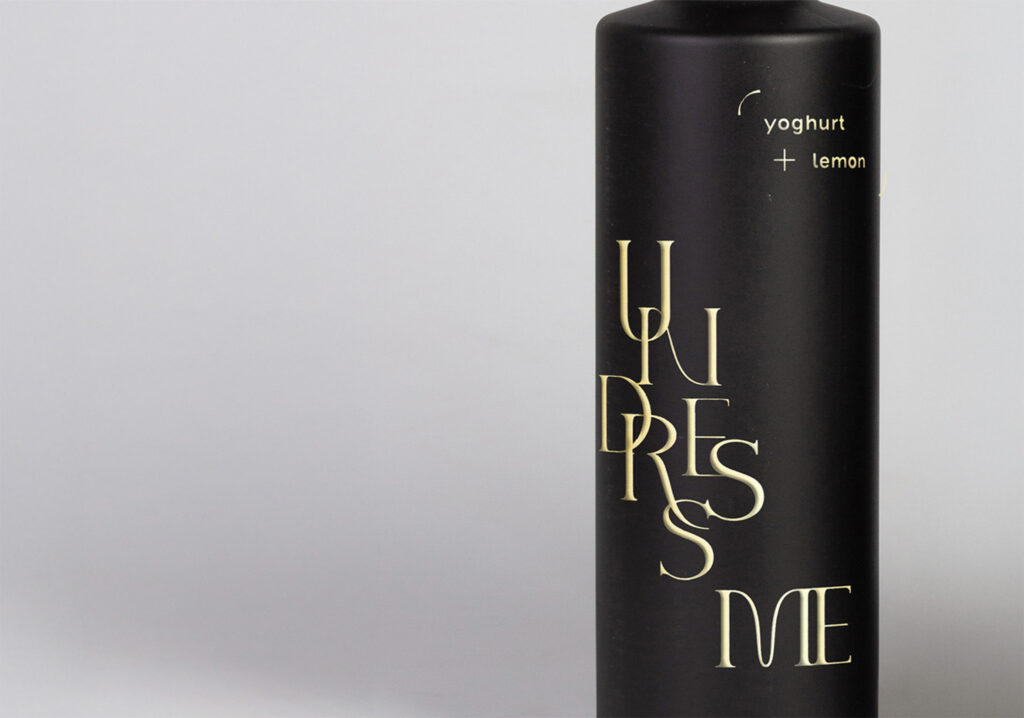 one bottle of vinegar without the label in the shape of a jacket, with as title undress me, printed in gold directly on the bottle