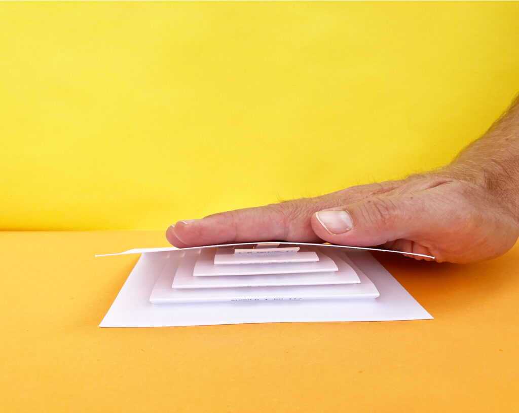 photo of a one third opened card with 3D steps, with on each step a motivational speech to get on the top of the stairs. A happy man is drawn on the top of the last step 