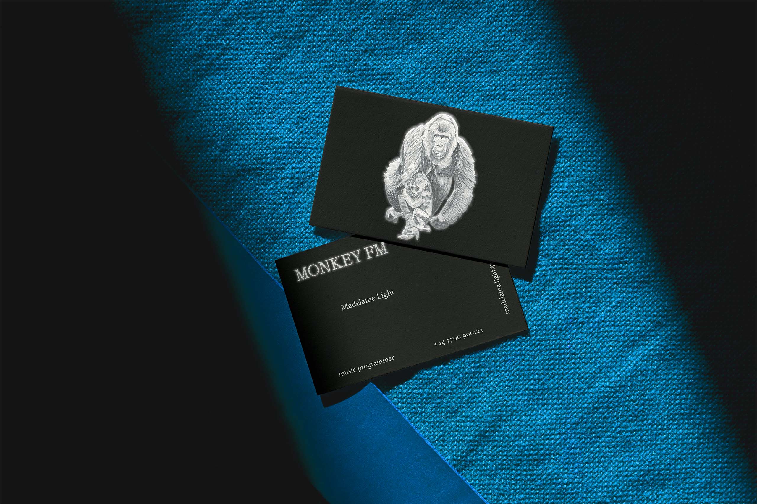 a black business card with a monkey mum and her kid drawn in pencil