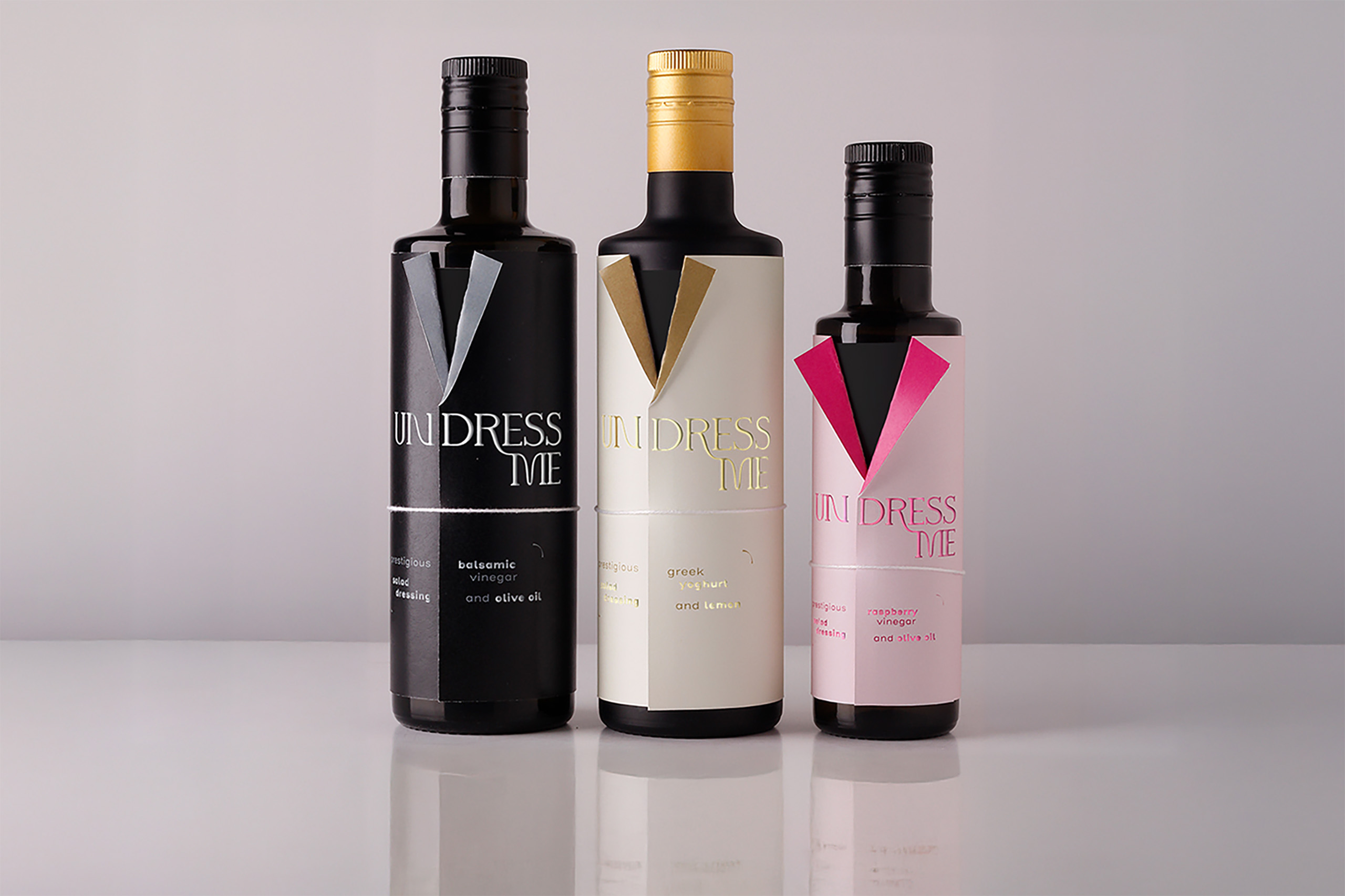 Three bottles of vinegar with a label in the shape of a jacket, with as title undress me