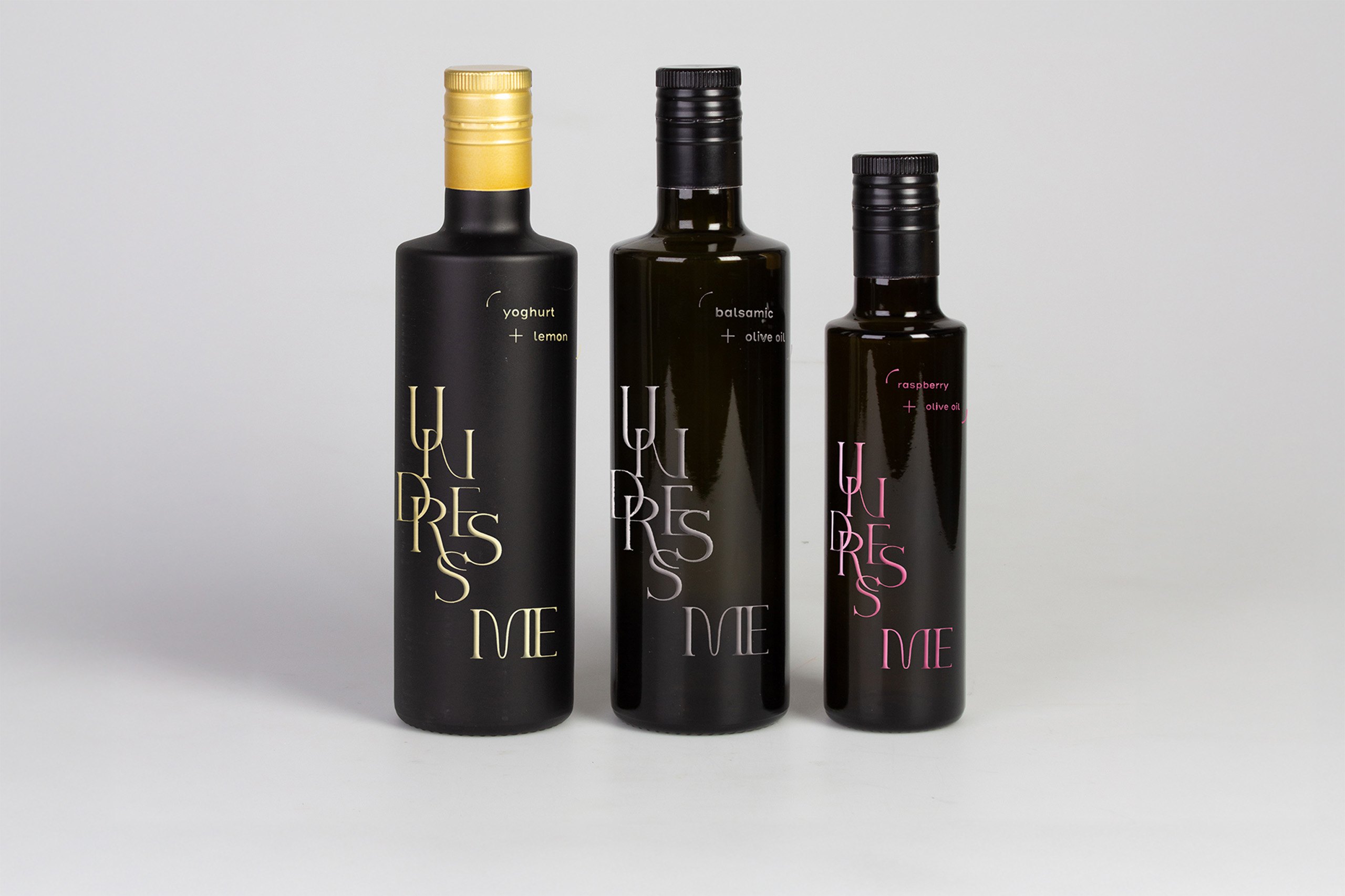 Three bottles of vinegar without the label in the shape of a jacket, with as title undress me, printed directly on the bottle