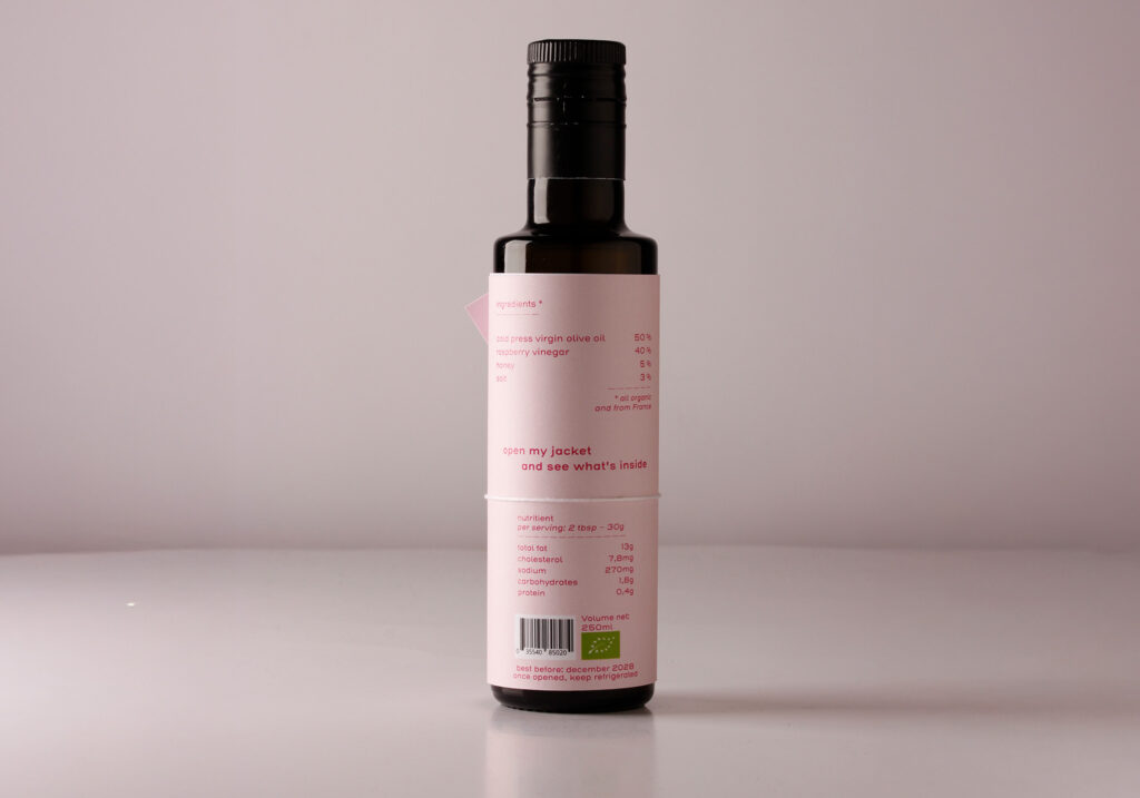 One bottle of vinegar with a label in the shape of a jacket, from the back side, with as title undress me, printed in pink