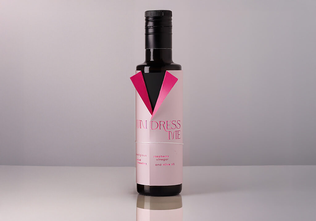 One bottle of vinegar with a label in the shape of a jacket, with as title undress me, printed in pink